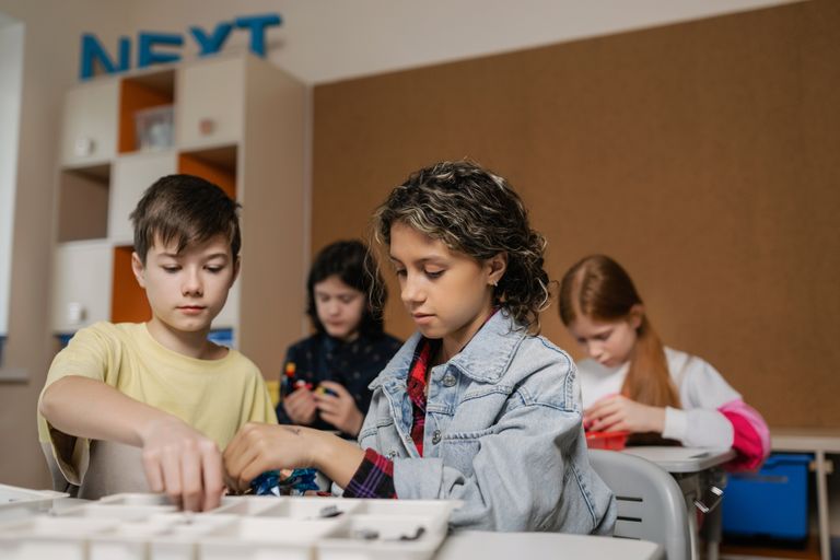 Children collaborating on robotics project in a classroom setting, fostering technology learning.